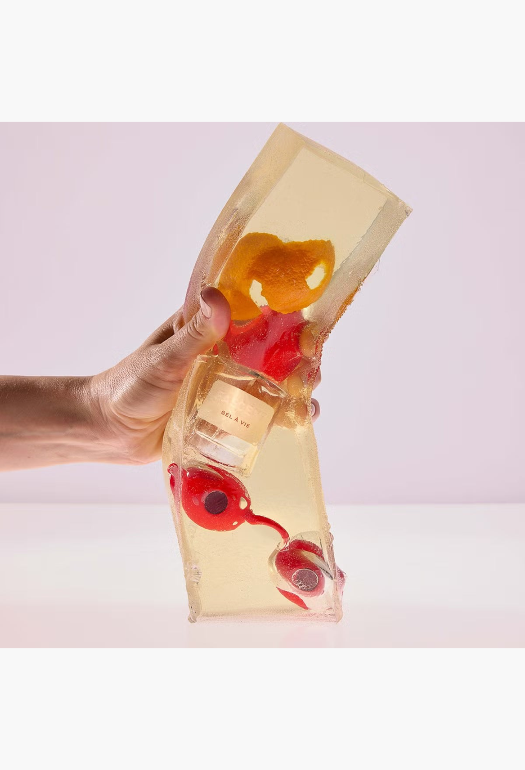 GLAM MODA Fascent Sel À Vie perfume bottle encased in a textured golden resin block with orange peel and red berries