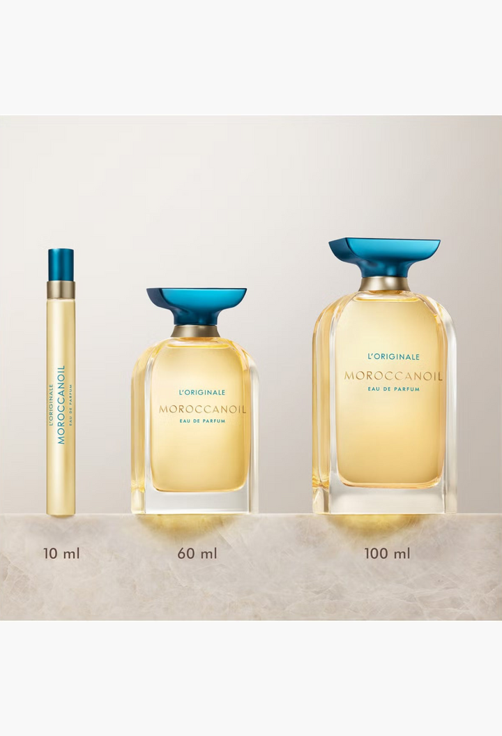 GLAM MODA Moroccanoil L'Originale Eau de Parfum collection in 10ml, 60ml, and 100ml glass bottles with blue caps.