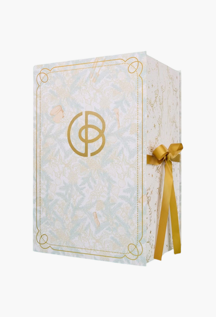 GLAM MODA beauty advent calendar featuring intricate botanical illustrations, gold logo, and a festive ribbon tie.