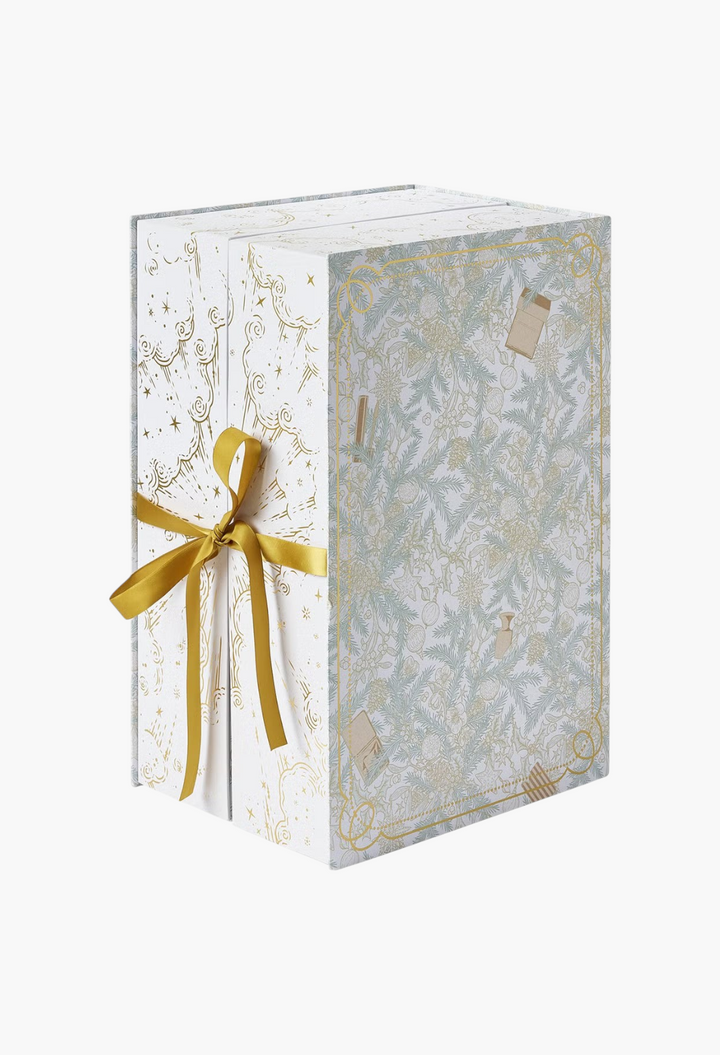 GLAM MODA beauty advent calendar in a white box with gold ribbon and intricate botanical and festive illustrations.