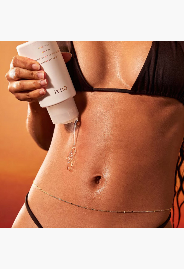 GLAM MODA OUAI St. Barts Body Cleanser gel being poured onto skin by a woman in a black bikini