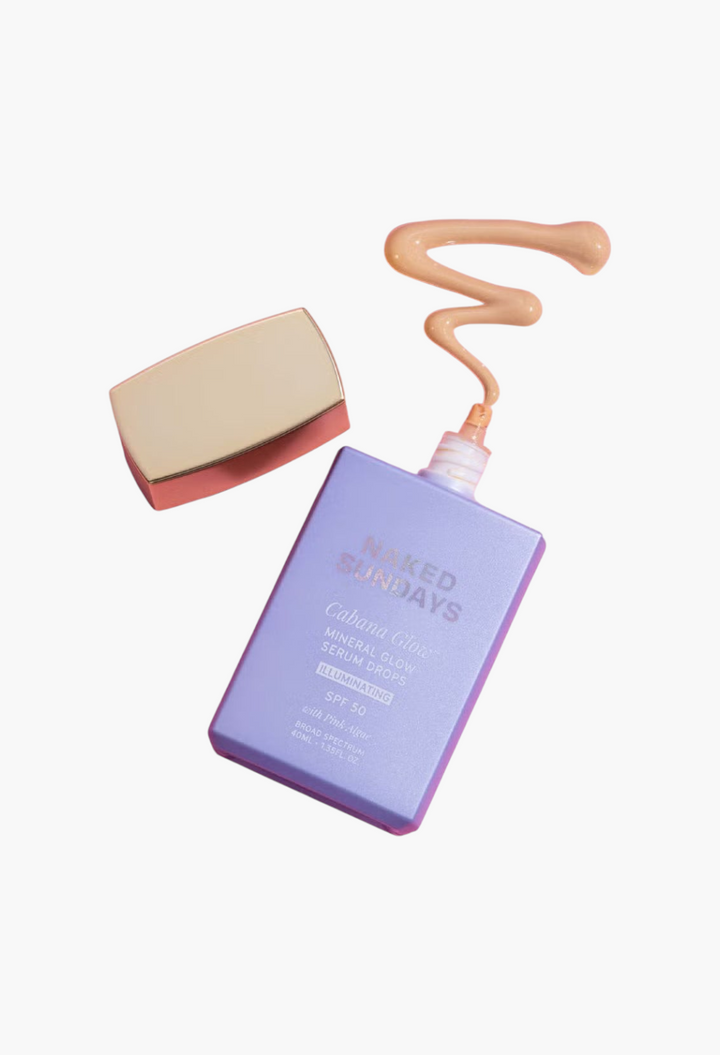 GLAM MODA Naked Sundays Cabana Glow SPF50 illuminating mineral serum drops with a gold cap on a pink background.