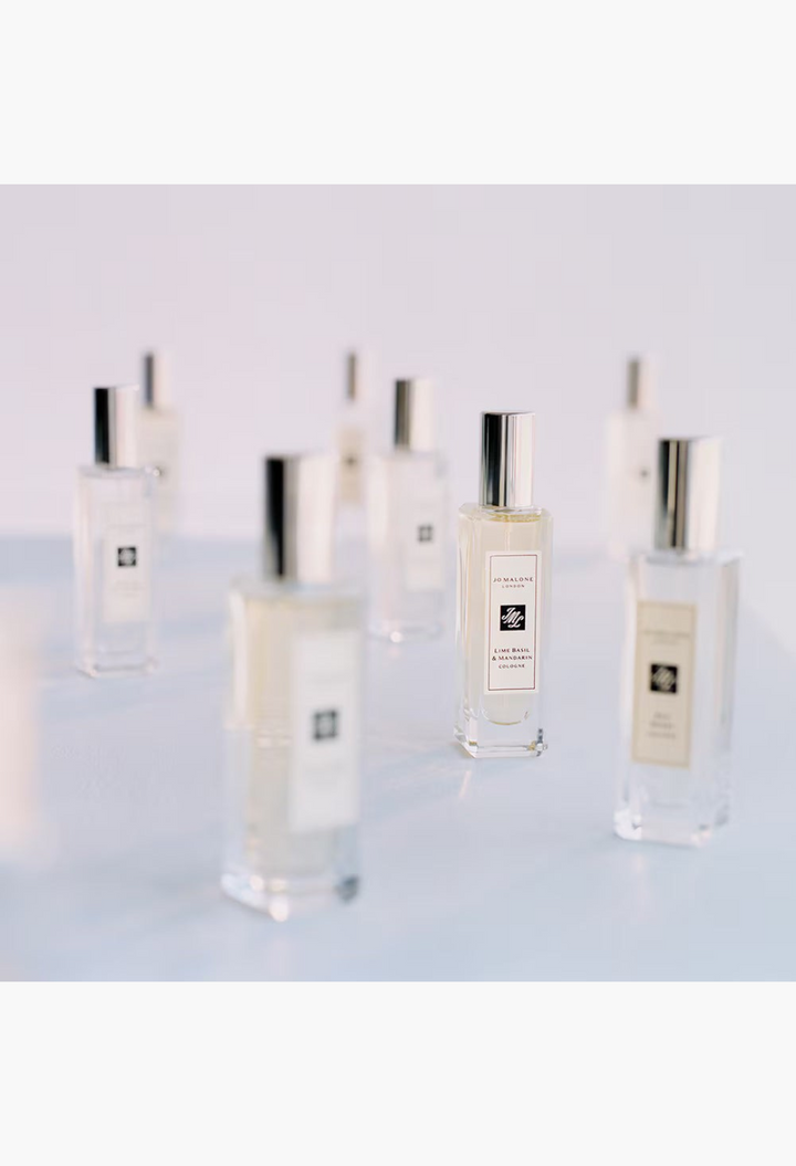 GLAM MODA Grapefruit Cologne in a clear glass bottle with a silver cap, surrounded by other fragrance bottles.