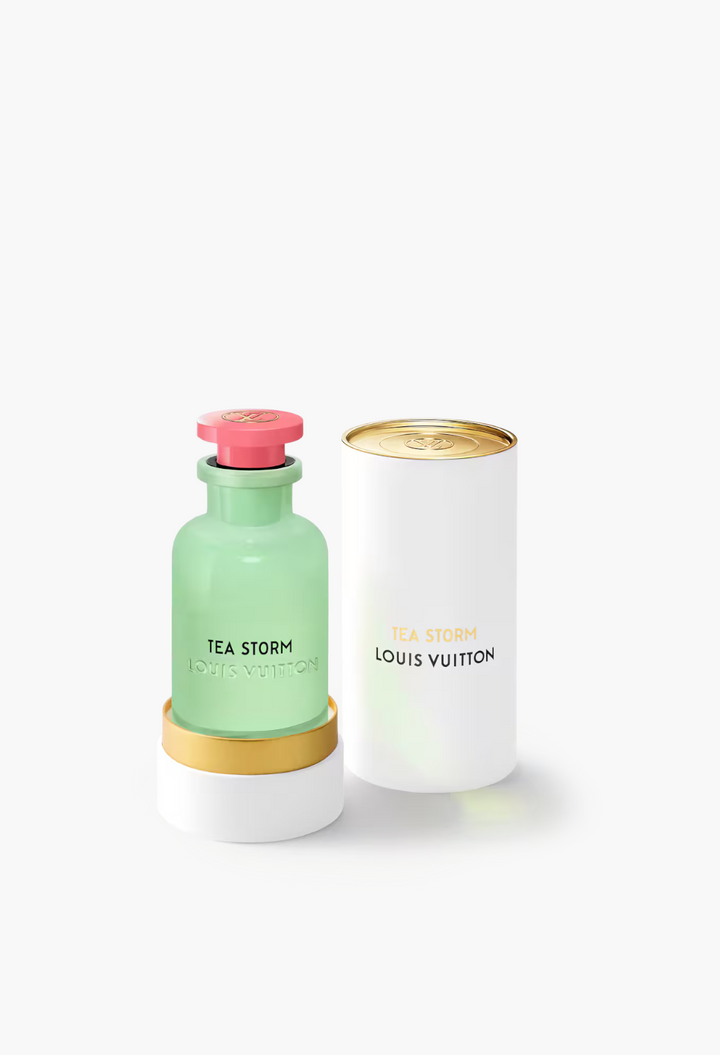 GLAM MODA Louis Vuitton Tea Storm perfume bottle in opalescent green glass with a pink cap and matching white case.