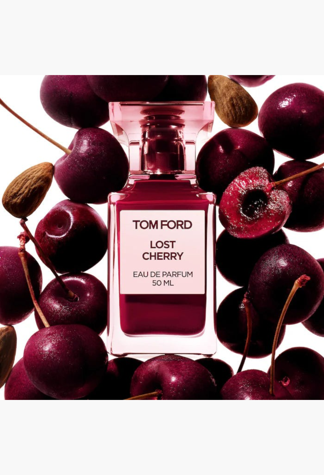 GLAM MODA Tom Ford Lost Cherry Eau de Parfum bottle surrounded by fresh black cherries and almonds
