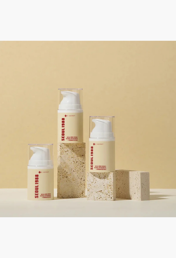 GLAM MODA K Secret Seoul 1988 anti-aging cream bottles with retinol and rice ferment on stone pedestals