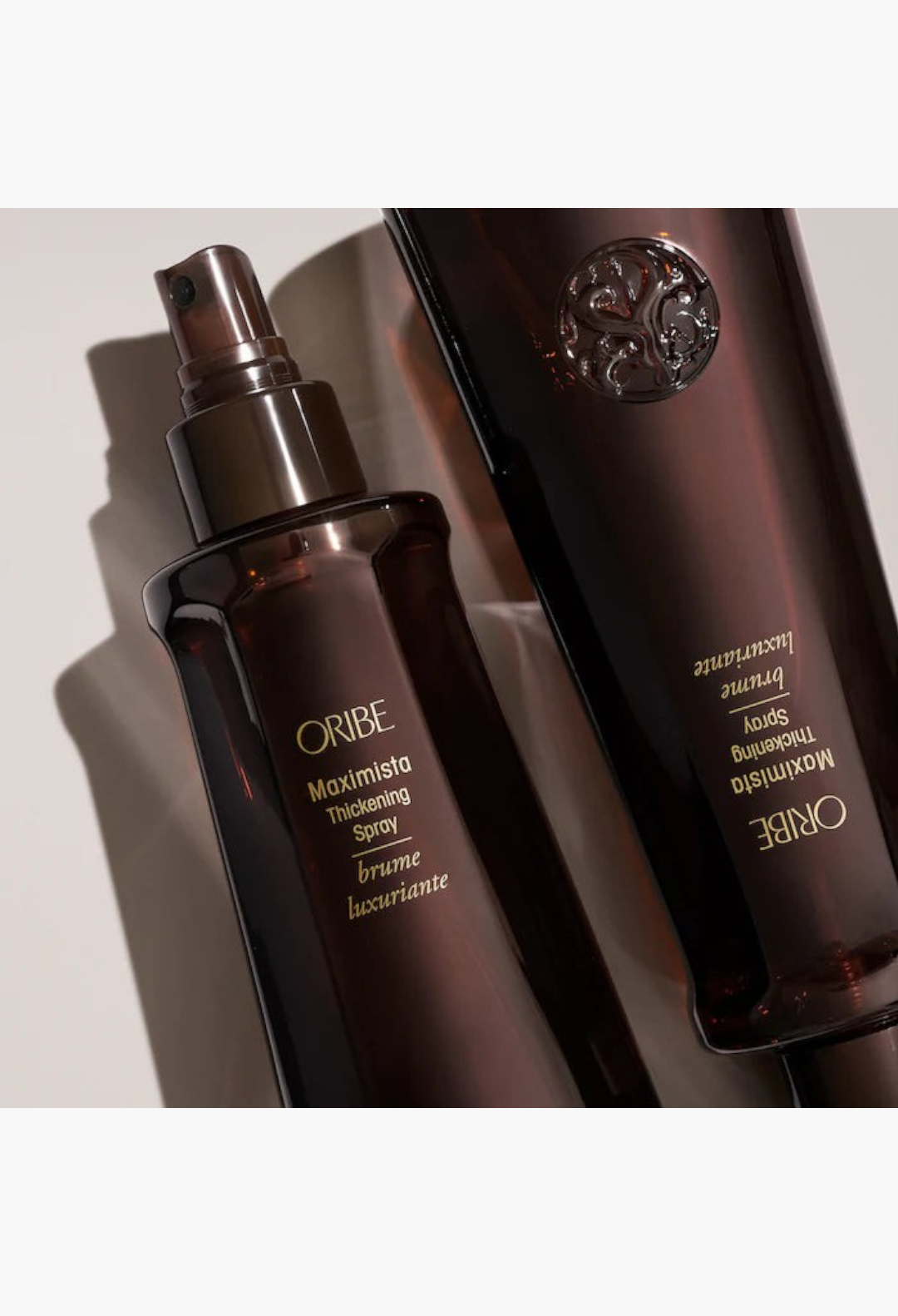 GLAM MODA Oribe Maximista Thickening Spray in dark brown bottles for volumizing fine hair with heat protection.
