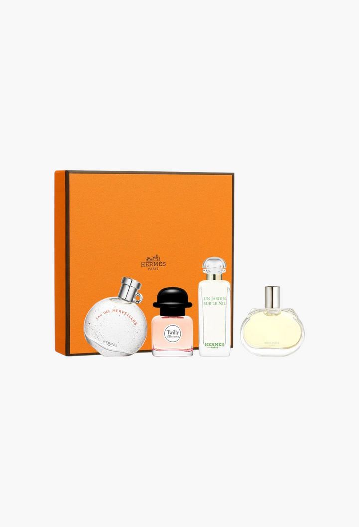 GLAM MODA Hermès fragrance discovery set featuring four mini perfume bottles in front of a signature orange gift box.