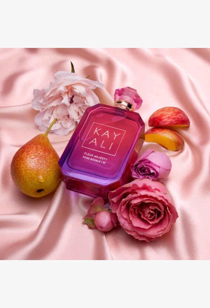 GLAM MODA KAYALI Fleur Majesty Rose Royale perfume bottle surrounded by fresh pink roses and ripe pears