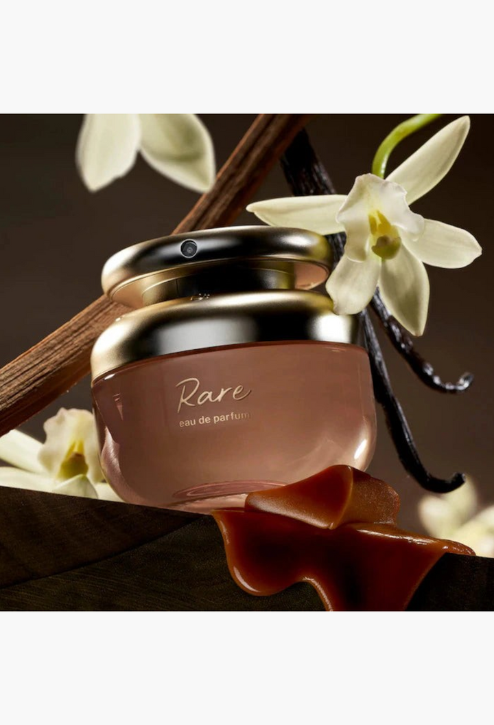 GLAM MODA Rare Beauty perfume bottle with vanilla bean and flower accents on a clean background