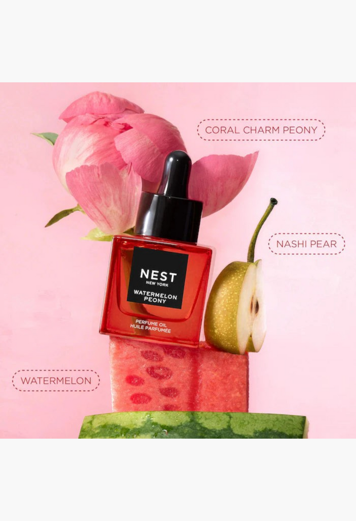 GLAM MODA Nest New York Watermelon Peony perfume oil bottle displayed with fresh watermelon slices, a pear, and a peony.