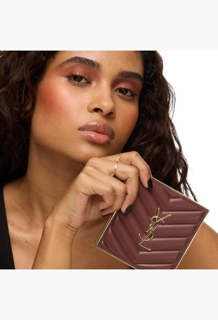 GLAM MODA model holding the YSL Brewed Reflections Couture Face Palette in an espresso-toned quilted clutch case
