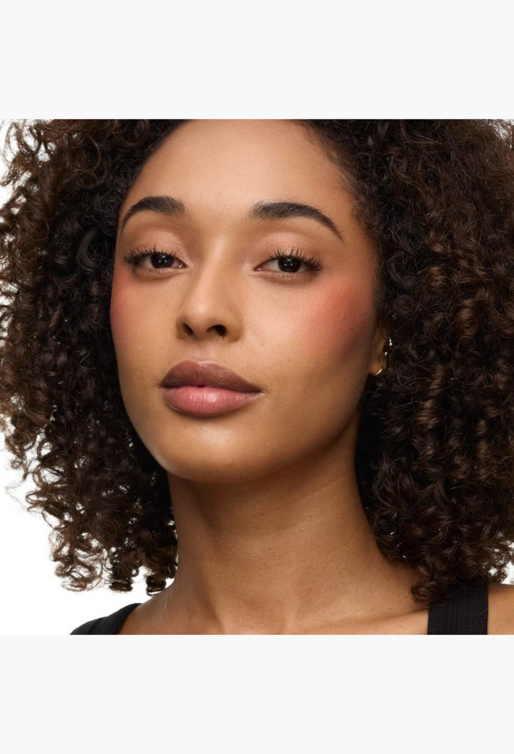 GLAM MODA model with curly hair wearing YSL Brewed Reflections Couture Face Palette blush for a soft-diffused flush
