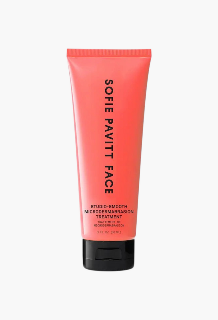 GLAM MODA Studio-Smooth Microdermabrasion exfoliating scrub in a coral-orange squeeze tube with black cap.