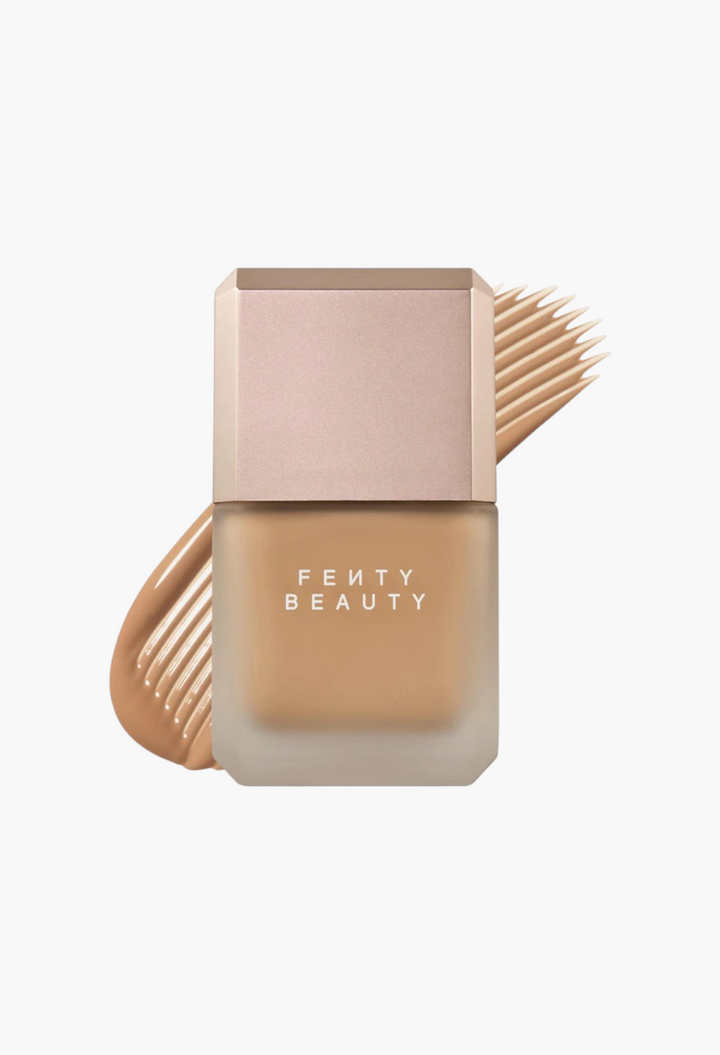 GLAM MODA Fenty Beauty Pro Filt'r liquid foundation bottle with a matte finish and a swatch of tan makeup behind it.