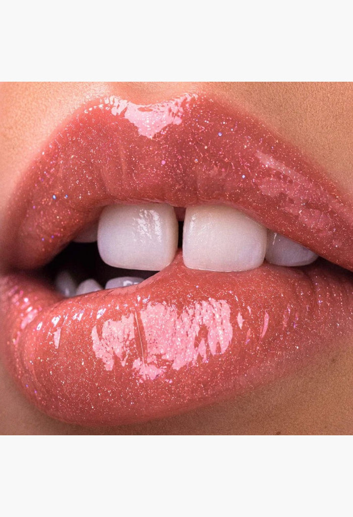 GLAM MODA Le Chouchou peptide lip balm applied on lips for a glossy, shimmering, and plumped finish.