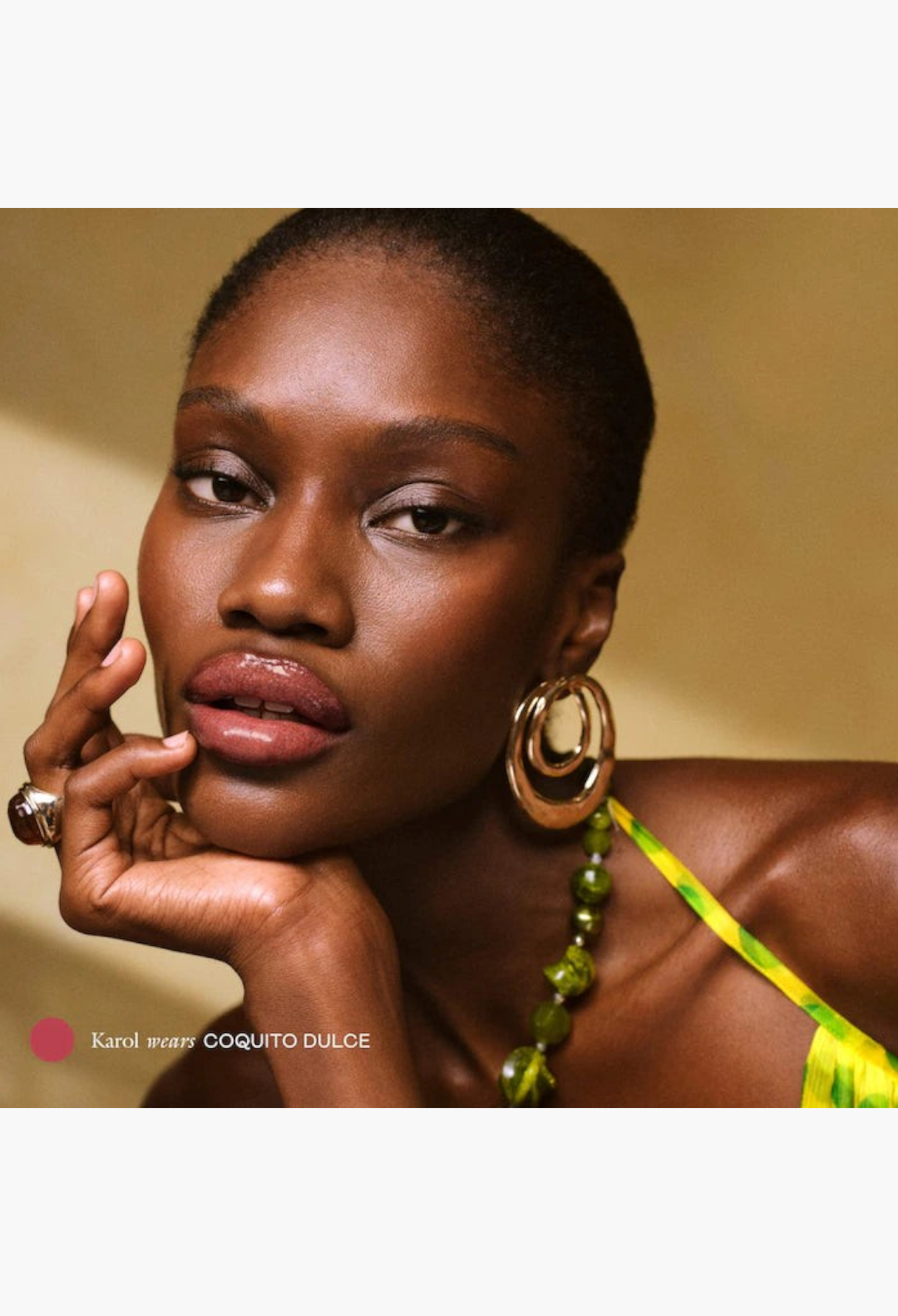 GLAM MODA model wearing Coquito Dulce peptide lip balm with a glossy, tinted finish and plump, hydrated lips.