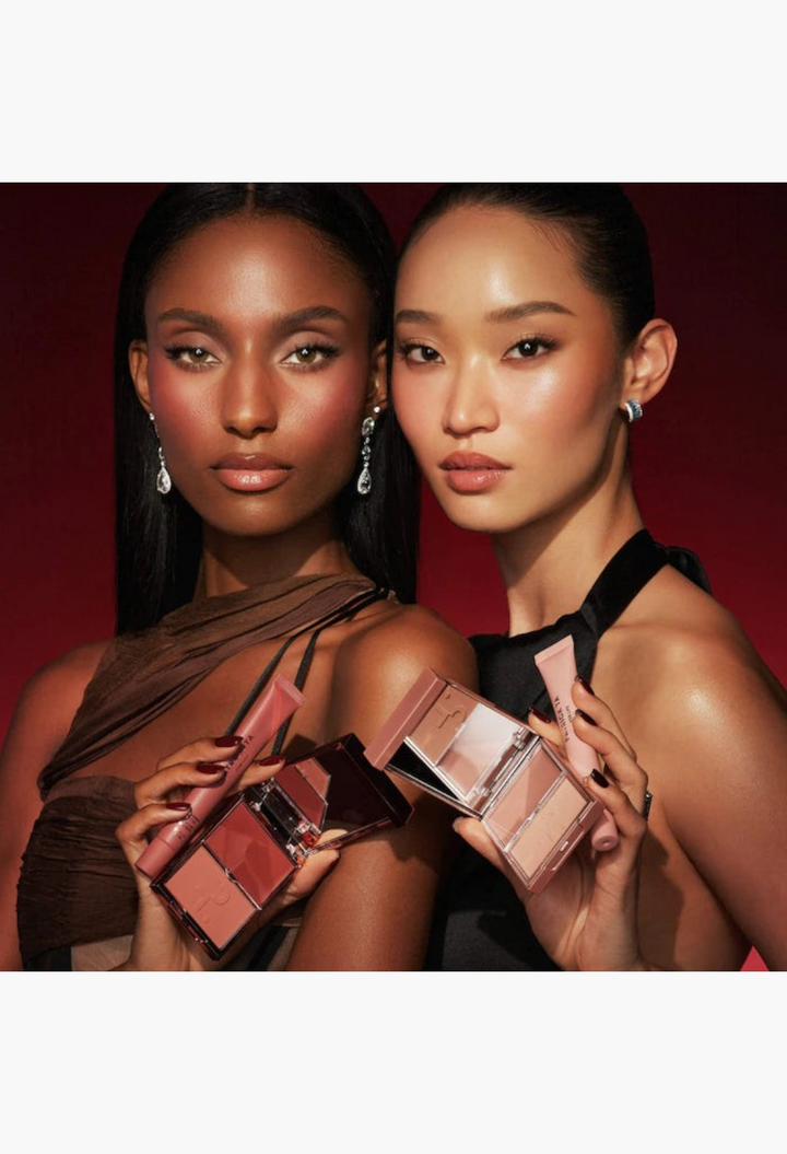 Two models holding GLAM MODA blush duos and lip balms in rosy pink and warm mocha shades for a holiday makeup look.