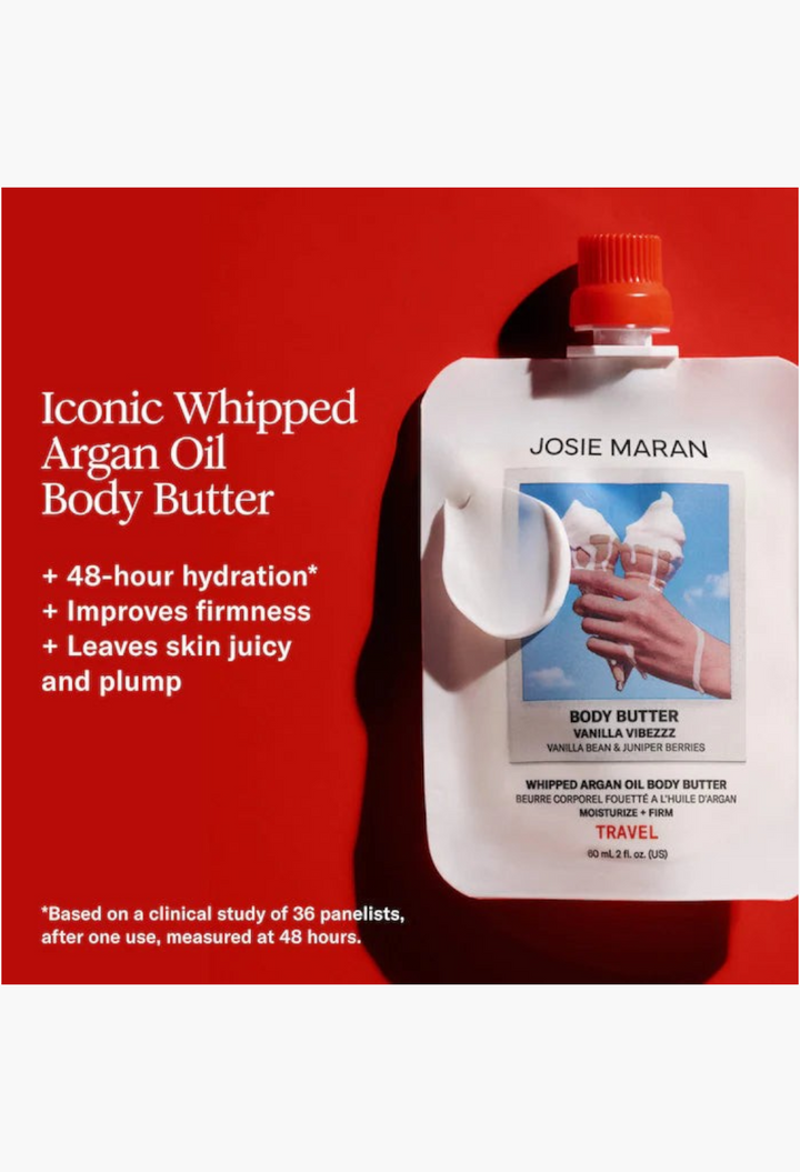 GLAM MODA Josie Maran travel-size whipped argan oil body butter pouch with vanilla scent and creamy texture on red background
