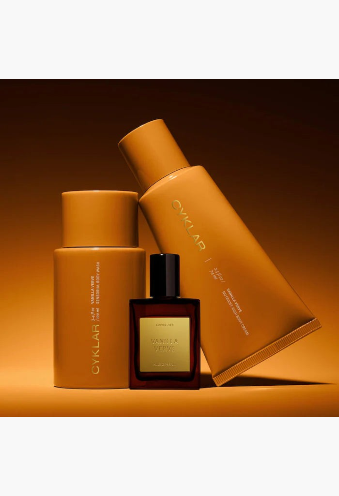 GLAM MODA Vanilla Verve gift set featuring a body wash bottle, body cream tube, and perfume oil in warm amber tones.