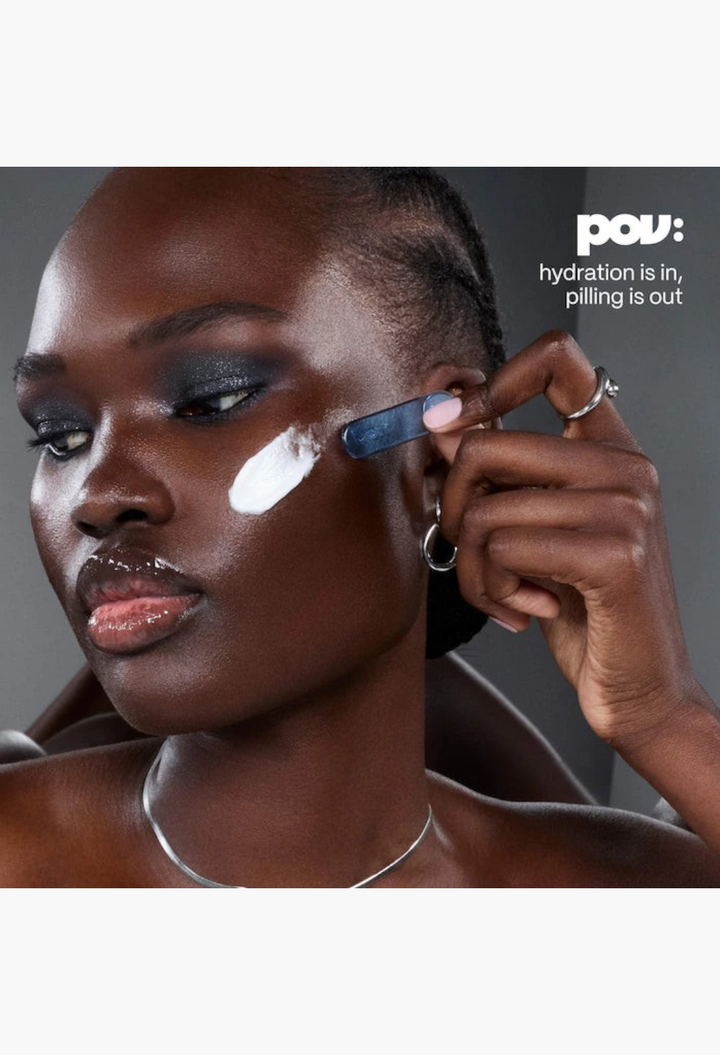 GLAM MODA model applying white whipped face cream with a blue spatula for skin barrier support and hydration