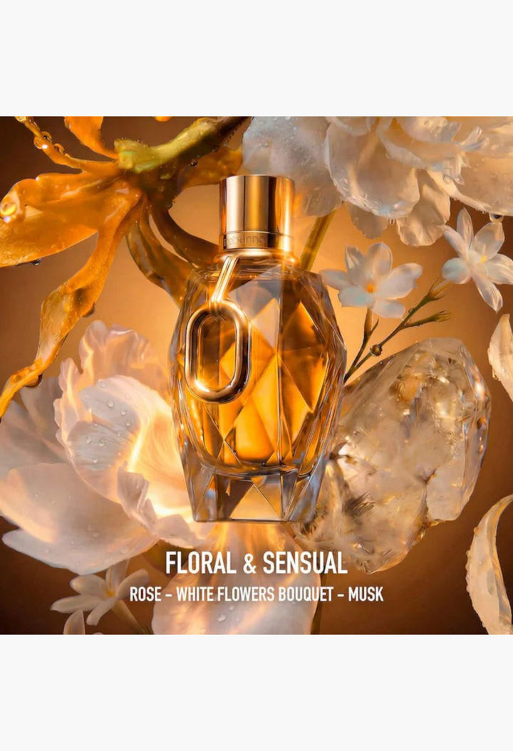 GLAM MODA perfume bottle surrounded by white flowers and glowing amber light, featuring a faceted glass design.
