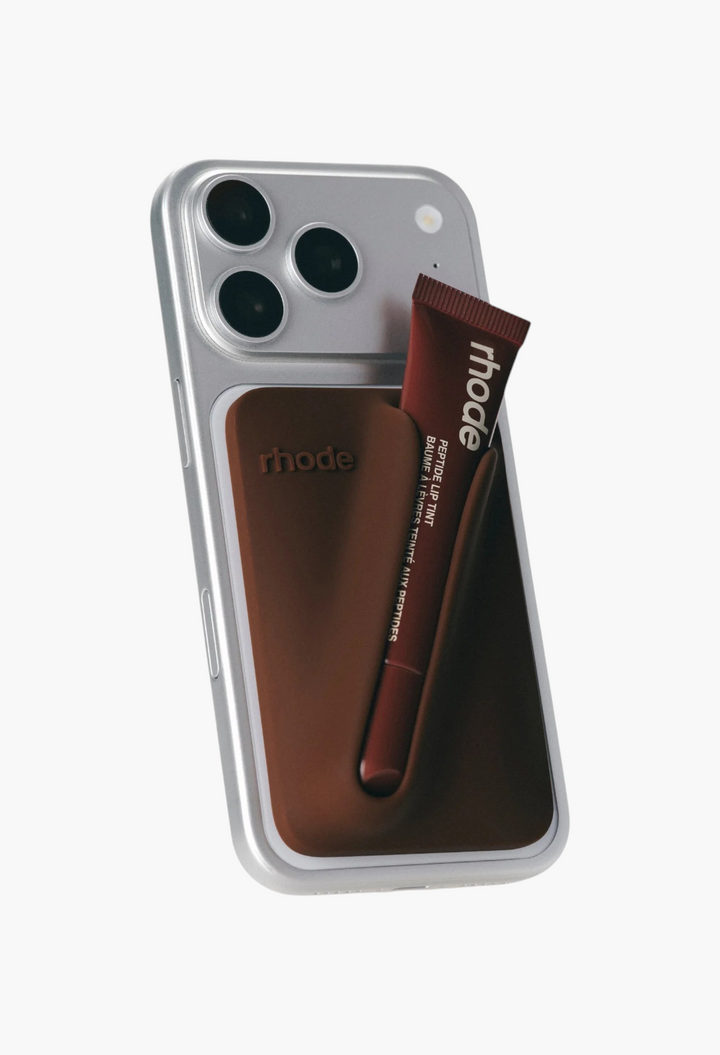 GLAM MODA bronze silicone snap-on lip case attached to a silver iPhone with a rhode peptide lip tint tube inserted