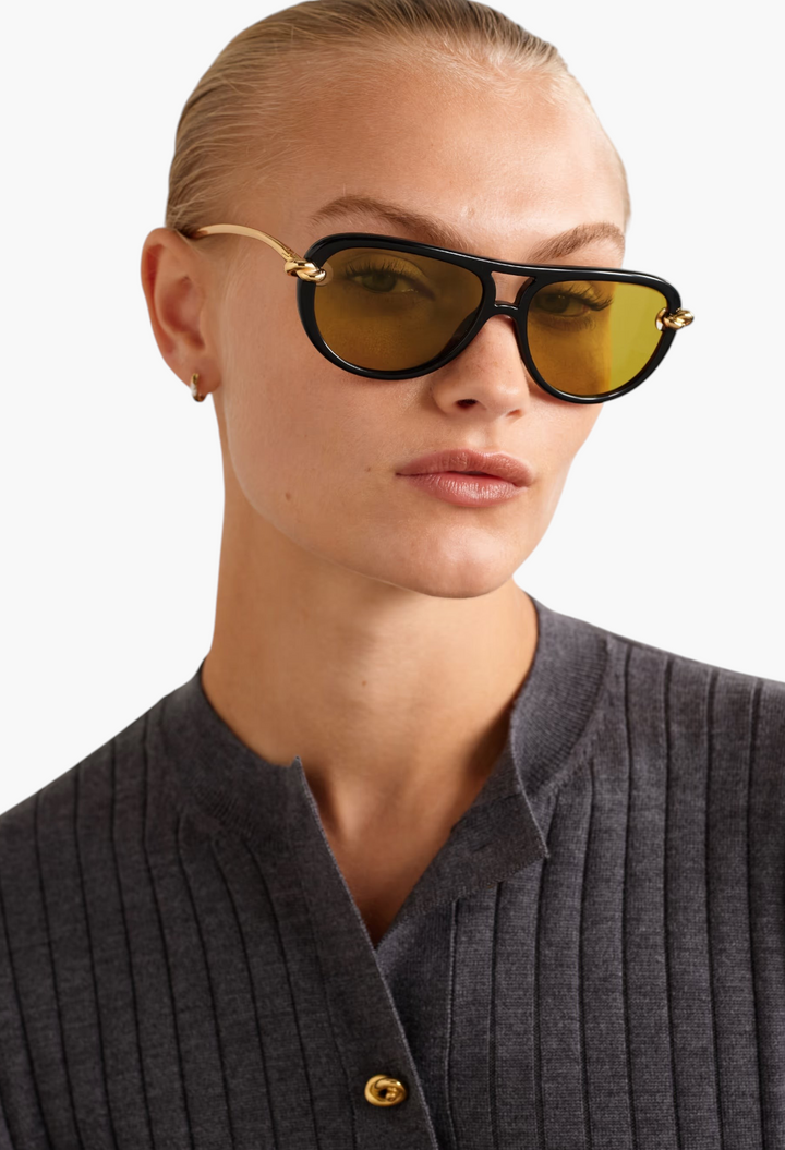 GLAM MODA New Knot aviator sunglasses with black frames, gold-tone twisted temples, and tinted lenses on a model