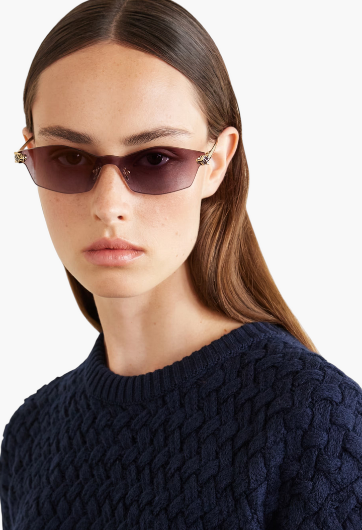 GLAM MODA Panthère de Cartier D-frame sunglasses with gold-tone metal temples and purple tinted lenses on a model.