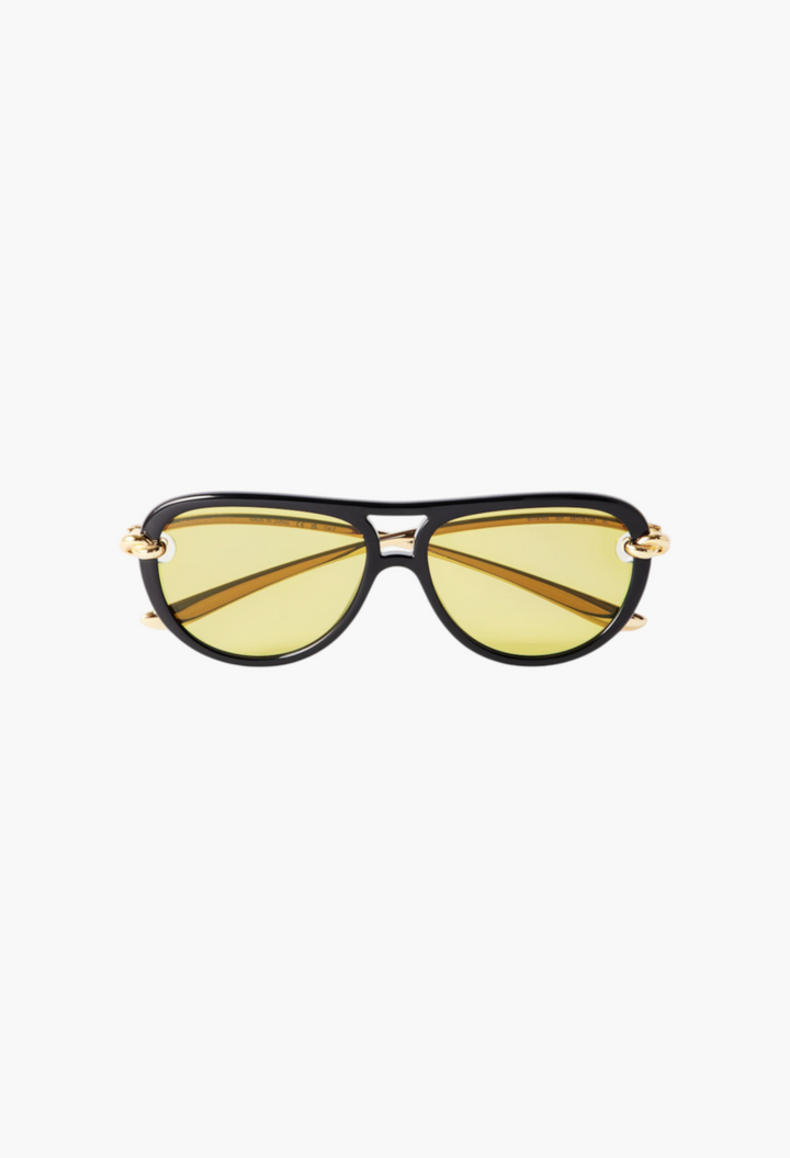 GLAM MODA New Knot aviator sunglasses featuring black frames, yellow lenses, and gold-tone twisted metal temples.